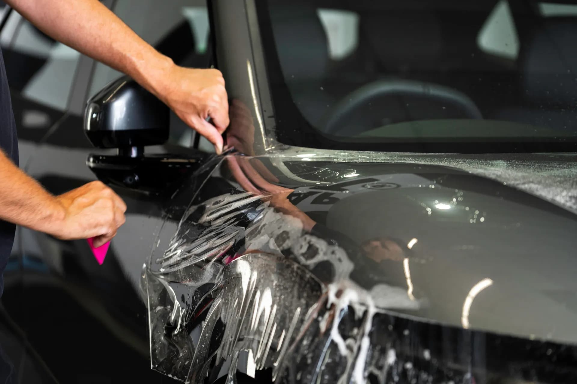 Paint protection film being applied to a vehicle's front panel